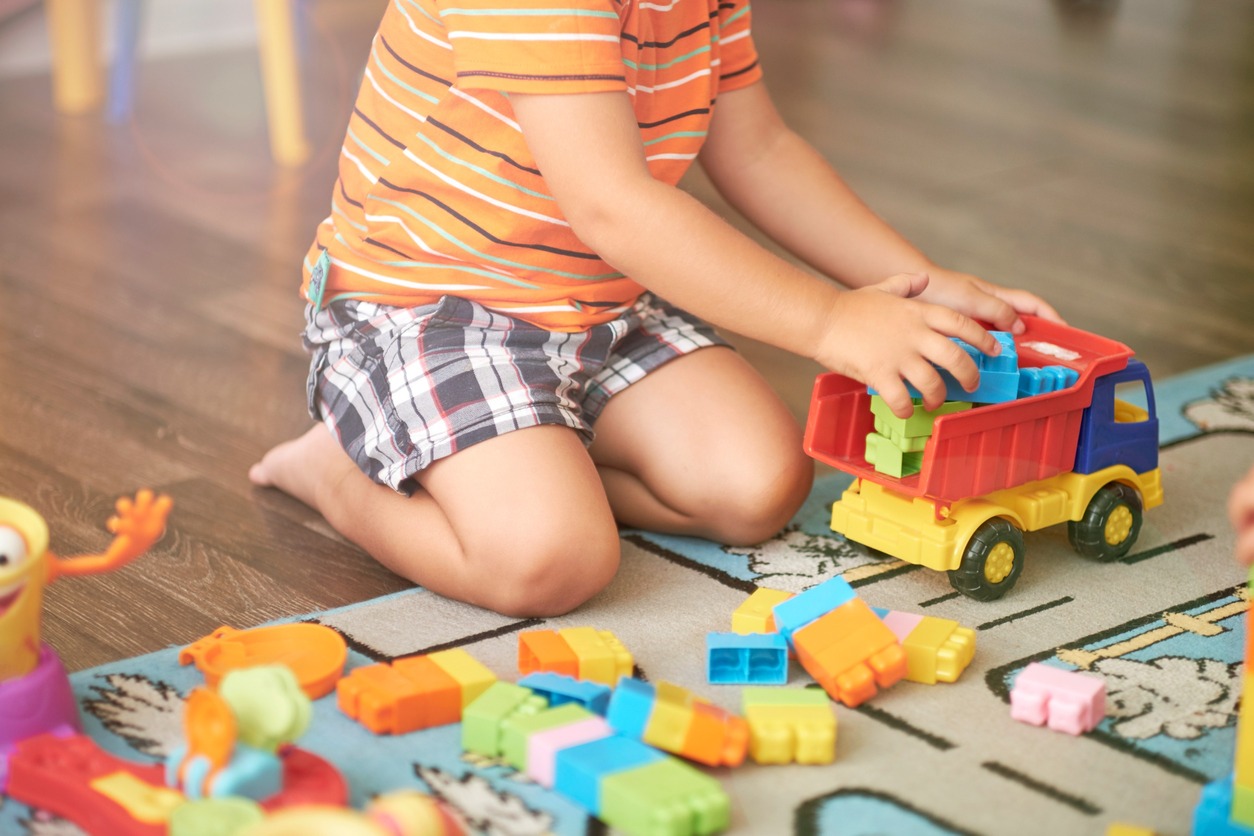 recorte niño jugando con camion en alfombra infantil